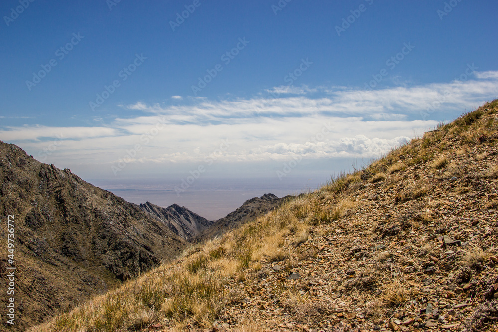Beautiful Summer scenery: yellow and brown mountains under the blue cloudy sky. Central Asian mountain background. 