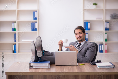 Young male employee drinking coffee during break