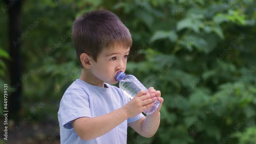 little boy drinking water from plastic bottle outdoors little boy drinking water from plastic bottle outdoors