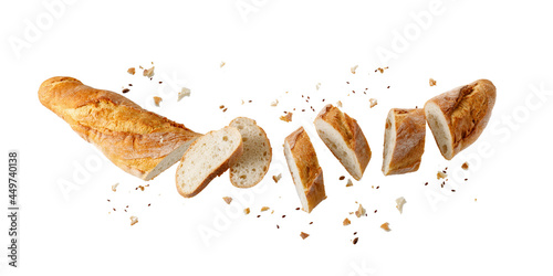 Obraz na plátne Cutting fresh baked loaf wheat baguette bread  with crumbs and seeds flying isol