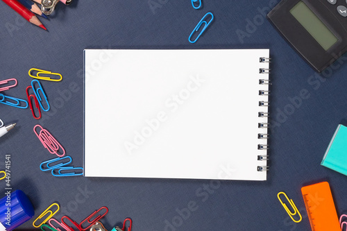 Notepad and school supplies on a blue background