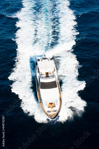 View from above, stunning aerial view of a luxury yacht cruising on a blue water creating a wake. Costa Smeralda, Sardinia, Italy. © Travel Wild