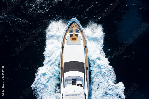 View from above, stunning aerial view of a luxury yacht cruising on a blue water creating a wake. Costa Smeralda, Sardinia, Italy. © Travel Wild