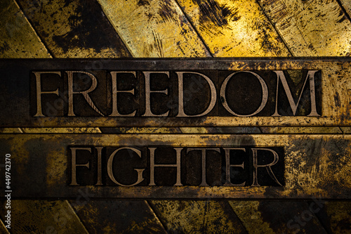 Foto Freedom Fighter text message on grunge textured copper and gold background
