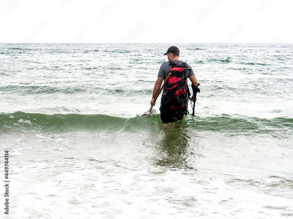 treasure seeker at sea with a metal detector treasure seeker at sea with a metal detector