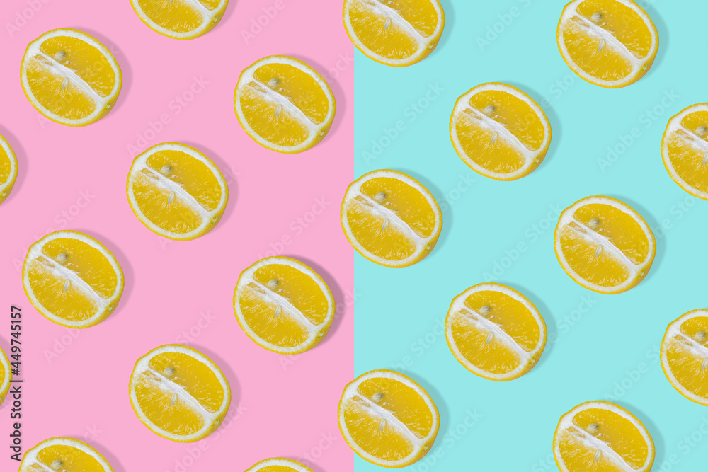 Trendy summer idea with yellow lemon halves on bright pink and blue background. Trendy summer idea with yellow lemon halves on bright pink and blue background.