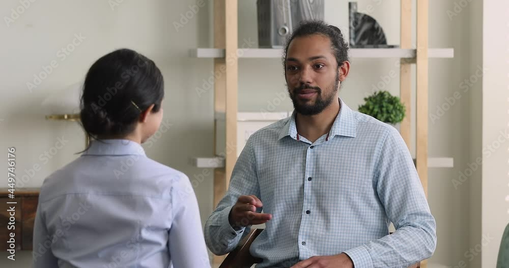 Diverse deaf people communicating with sign language while sit indoor during professional counselling meeting, two friends colleagues having conversations showing fingers gestures. Deafness concept
