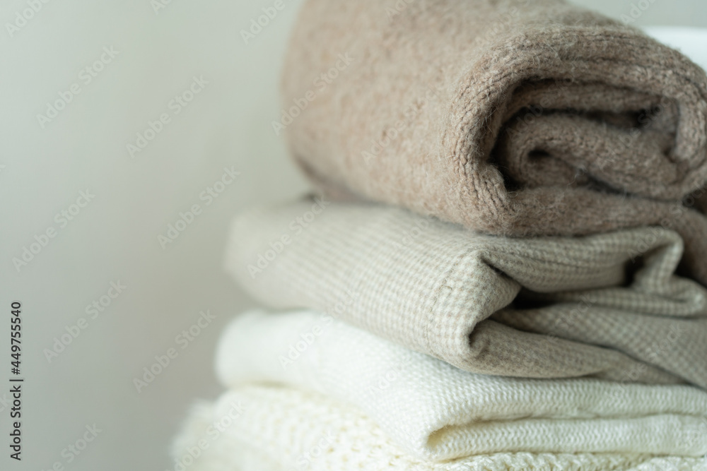 Pile of knitted sweaters. Warm background, knitwear, space for text. Autumn winter concept. Background with sweaters Pile of knitted sweaters. Warm background, knitwear, space for text. Autumn winter concept. Background with sweaters