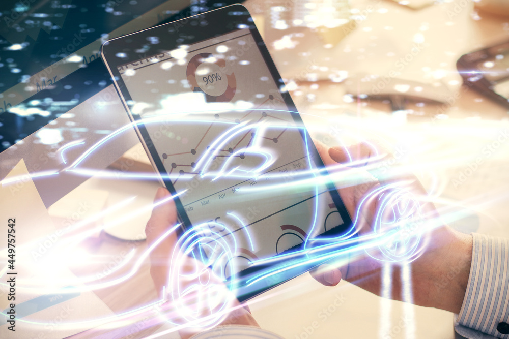 Double exposure of man's hands holding and using a digital device and automobile theme hologram drawing. Technology concept. Double exposure of man's hands holding and using a digital device and automobile theme hologram drawing. Technology concept.