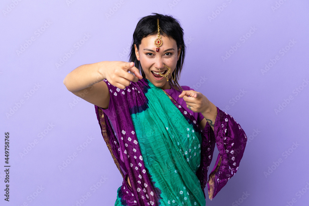 Indian woman isolated on purple background surprised and pointing front Indian woman isolated on purple background surprised and pointing front