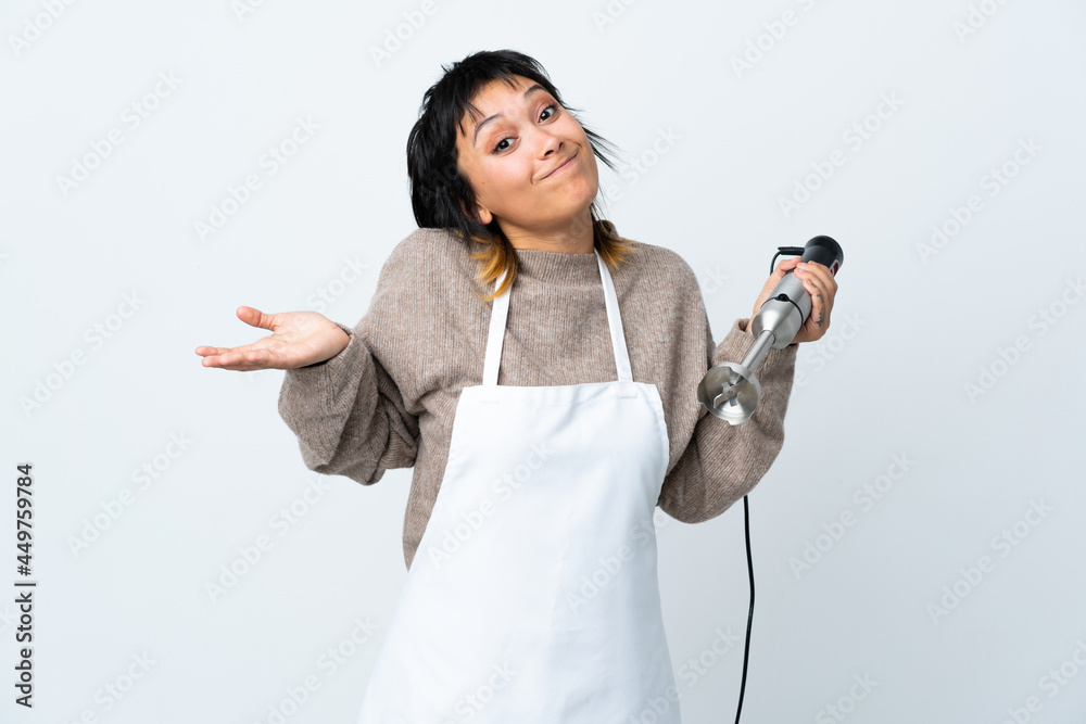 Chef Uruguayan girl using hand blender over isolated white background having doubts with confuse face expression Chef Uruguayan girl using hand blender over isolated white background having doubts with confuse face expression