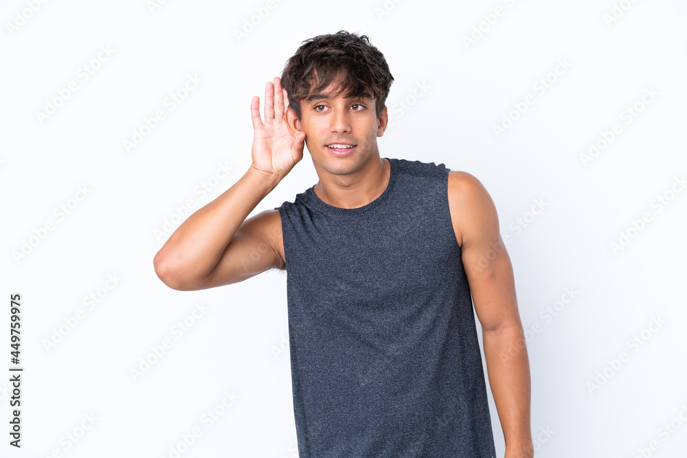 Young sport caucasian man isolated on white background listening to something by putting hand on the ear Young sport caucasian man isolated on white background listening to something by putting hand on the ear