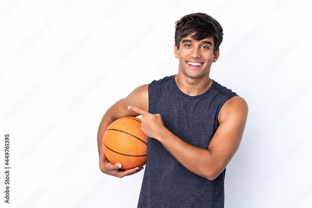 Young caucasian man isolated on white background playing basketball and pointing to the lateral Young caucasian man isolated on white background playing basketball and pointing to the lateral