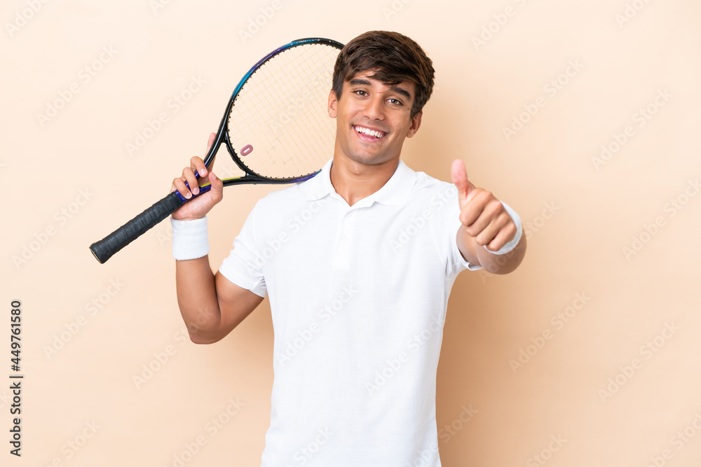 Young caucasian man isolated on ocher background playing tennis and with thumb up Young caucasian man isolated on ocher background playing tennis and with thumb up
