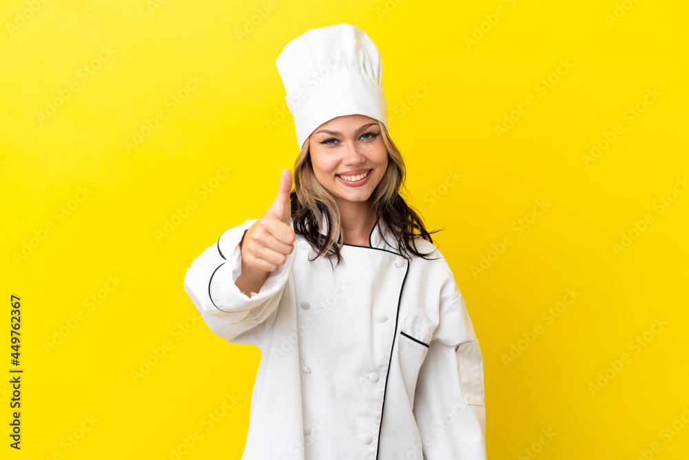 Young Russian chef girl isolated on yellow background with thumbs up because something good has happened Young Russian chef girl isolated on yellow background with thumbs up because something good has happened