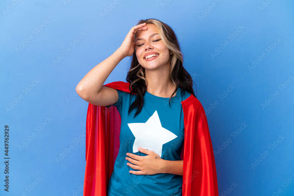 Super Hero Teenager girl isolated on blue background smiling a lot Super Hero Teenager girl isolated on blue background smiling a lot