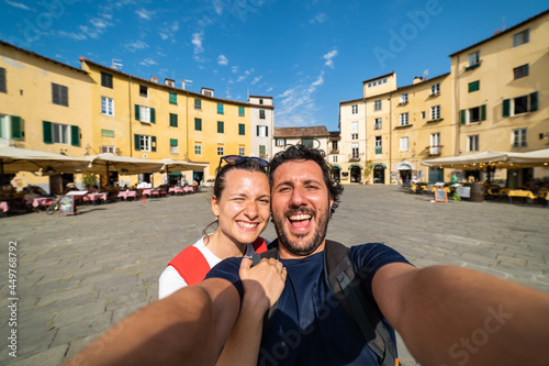 Travel tourists friends taking photo selfi with smartphone in Lucca, Tuscany. happy couple in love traveling in Europe having fun taking self-portrait picture traveling in Italy