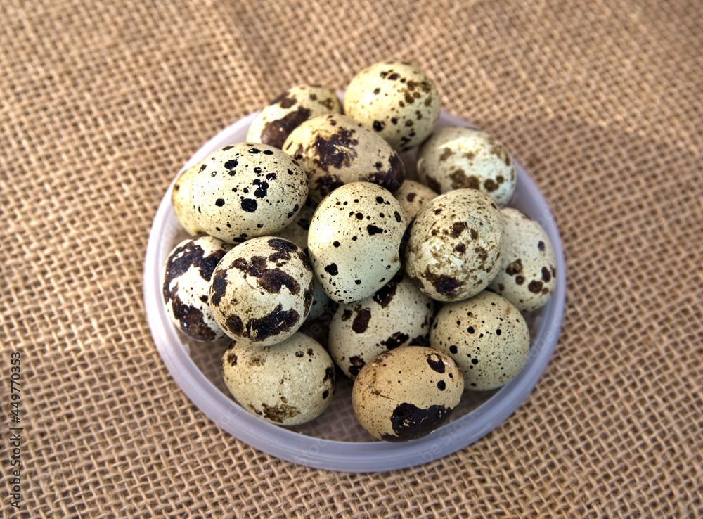FOOD: Close up of a bowl of quail eggs set on a burlap background.