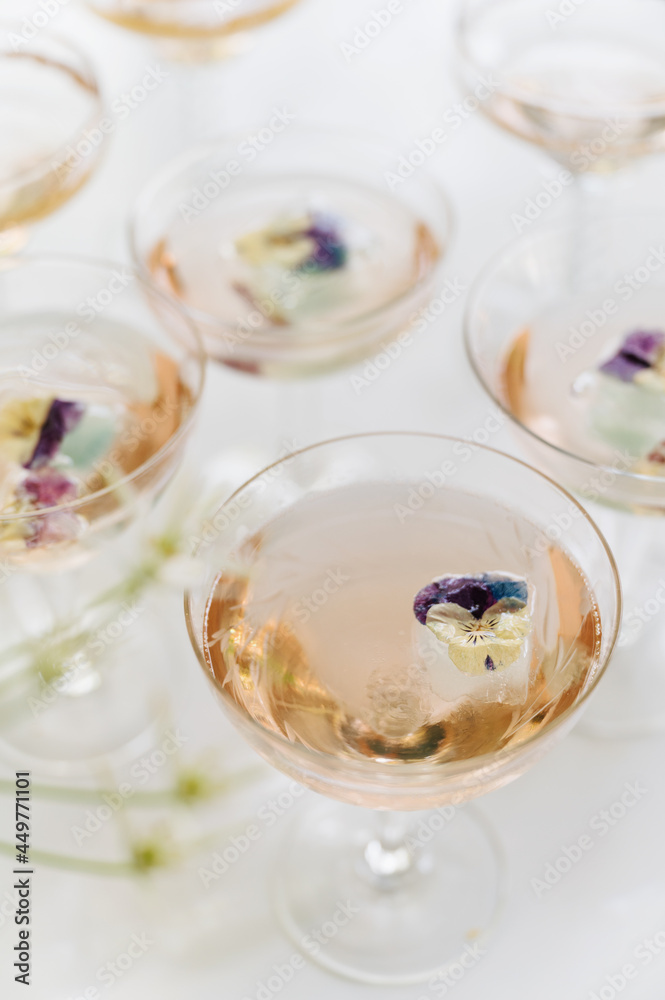 Sparkling rose wine with edible flower garnish Sparkling rose wine with edible flower garnish