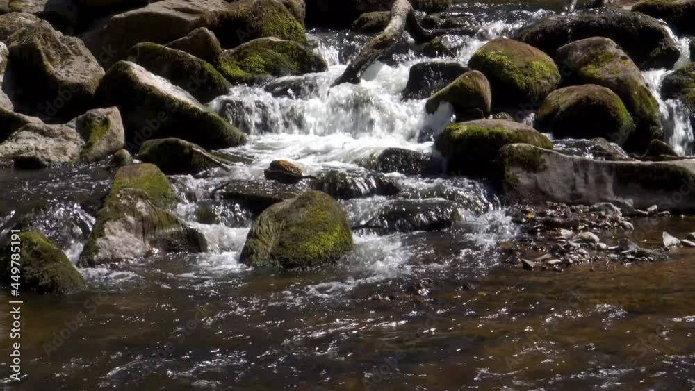 Fresh water flowing down the river teign in Dartmoor national park. Some mossy stones in the middle of the river. Fresh water flowing down the river teign in Dartmoor national park. Some mossy stones in the middle of the river.