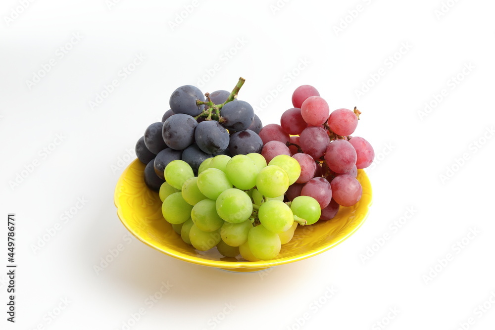 皿に盛られた小さな房の3種類のブドウ