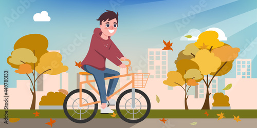 Young happy man ride a bicycle in the autumn.