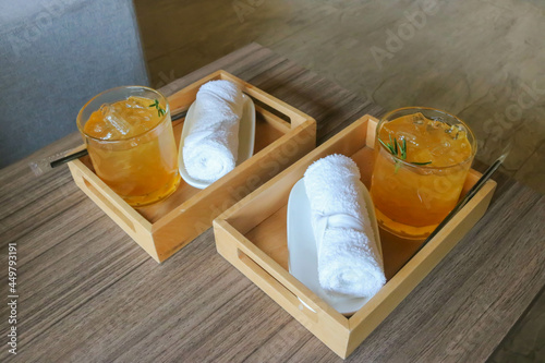 Welcome drink and cold towel on wooden tray for two people in luxury hotel