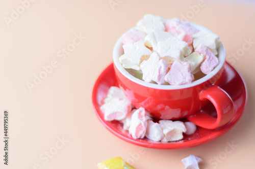 a cup of marhmallows against plain background. copy space. overexposed. soft focus. blurry background