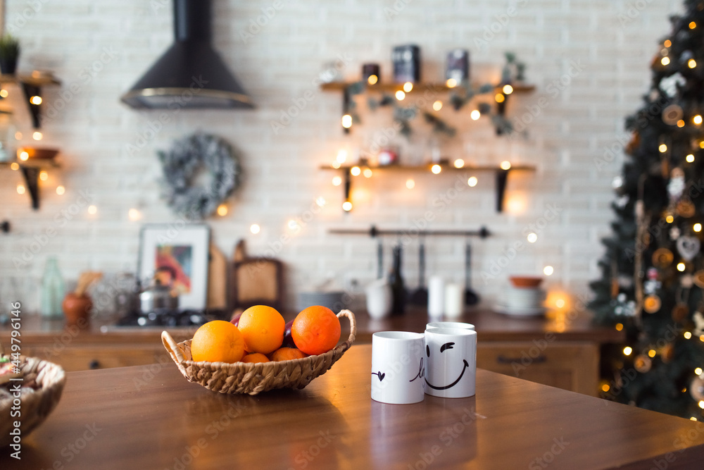 Christmas atmosphere - decorated fir tree and lights in the kitchen