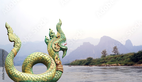 Statue of mythical asian naga snake and landscape with mountains and river Mekong