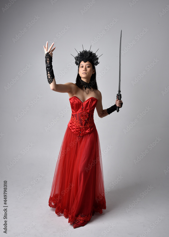 Full length portrait of beautiful young asian woman wearing red corset and  ornate gothic queen crown. Graceful standing posing isolated on studio  background. Photos | Adobe Stock