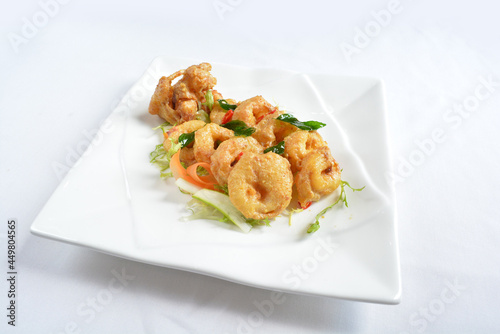 wok fried seafood octopus in pumpkin salted egg yolk sauce seafood in white background asian halal menu