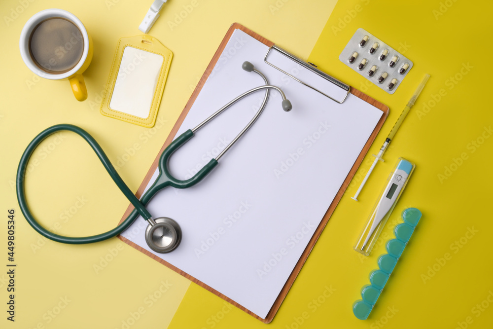 Stethoscope, clipboard, coffee cup and pills on yellow background. Stethoscope, clipboard, coffee cup and pills on yellow background.