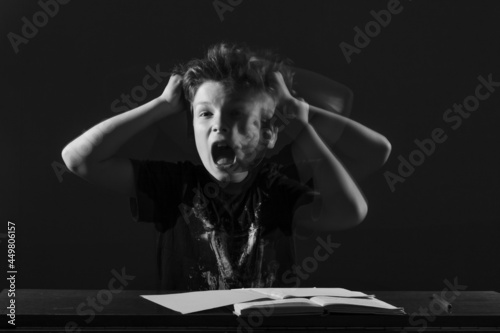 Tableau sur toile tired teenage schoolboy rage shouts, waves hands sitting table front book