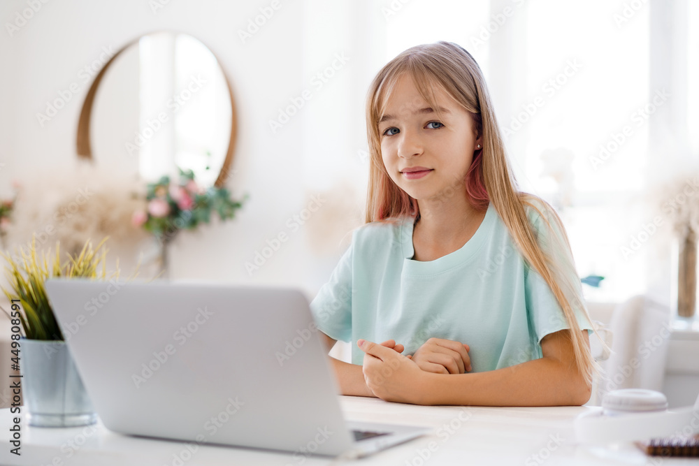 Happy little girl pupil using laptop at home Happy little girl pupil using laptop at home
