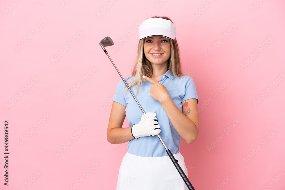 Young golfer player woman isolated on pink background pointing to the side to present a product Young golfer player woman isolated on pink background pointing to the side to present a product