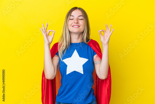 Super Hero Romanian woman isolated on yellow background in zen pose