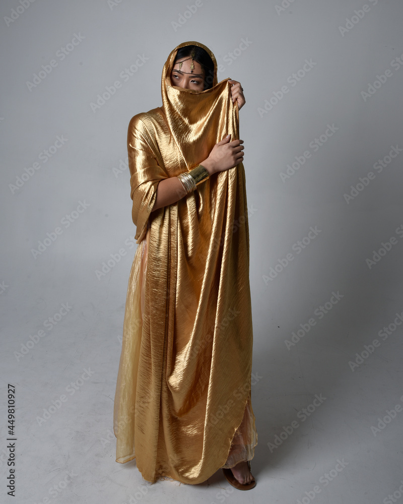 Full length portrait of pretty young asian woman wearing golden Arabian ...