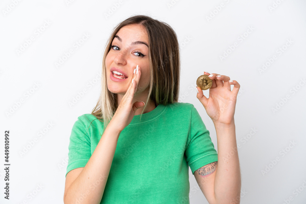 Young Romanian woman holding a Bitcoin isolated on white background whispering something Young Romanian woman holding a Bitcoin isolated on white background whispering something