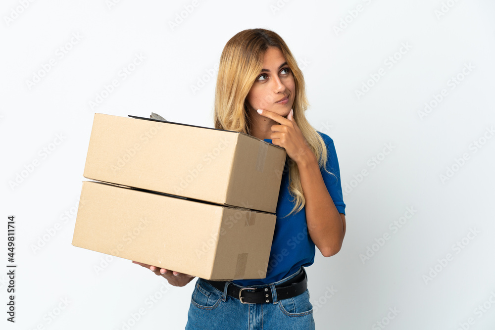 Young blonde Uruguayan delivery woman isolated on white background and looking up Young blonde Uruguayan delivery woman isolated on white background and looking up