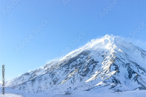 Russia  Natural Park  volcanoes of Kamchatka . The koryaksky volcano covered with snow and clouds on its rocks. The perfect weather for climbing. interesting and affordable for the tourists