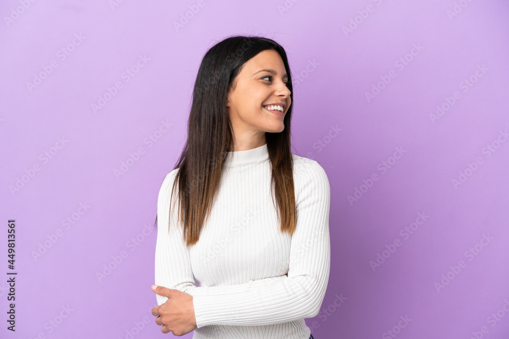 Obraz premium Young caucasian woman isolated on purple background looking to the side and smiling