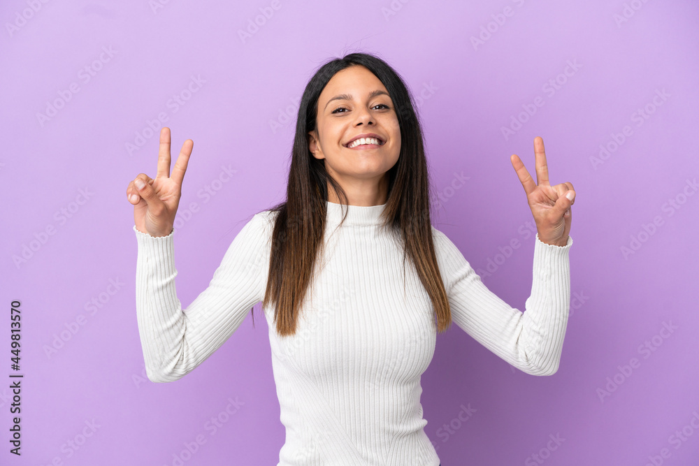 Young caucasian woman isolated on purple background showing victory sign with both hands Young caucasian woman isolated on purple background showing victory sign with both hands