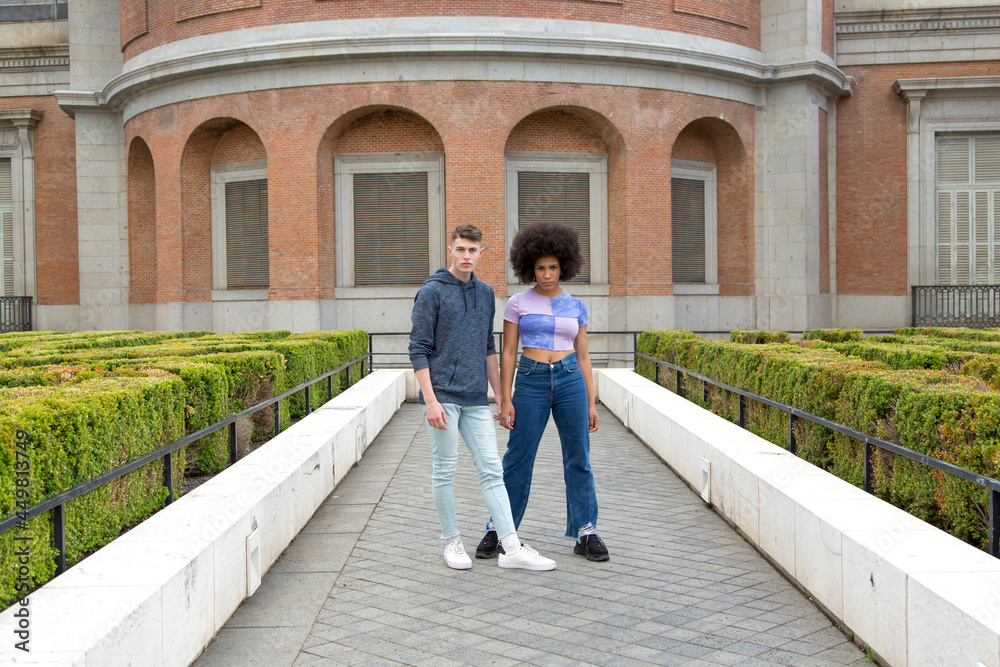 Young caucasian man and afro woman posing serious