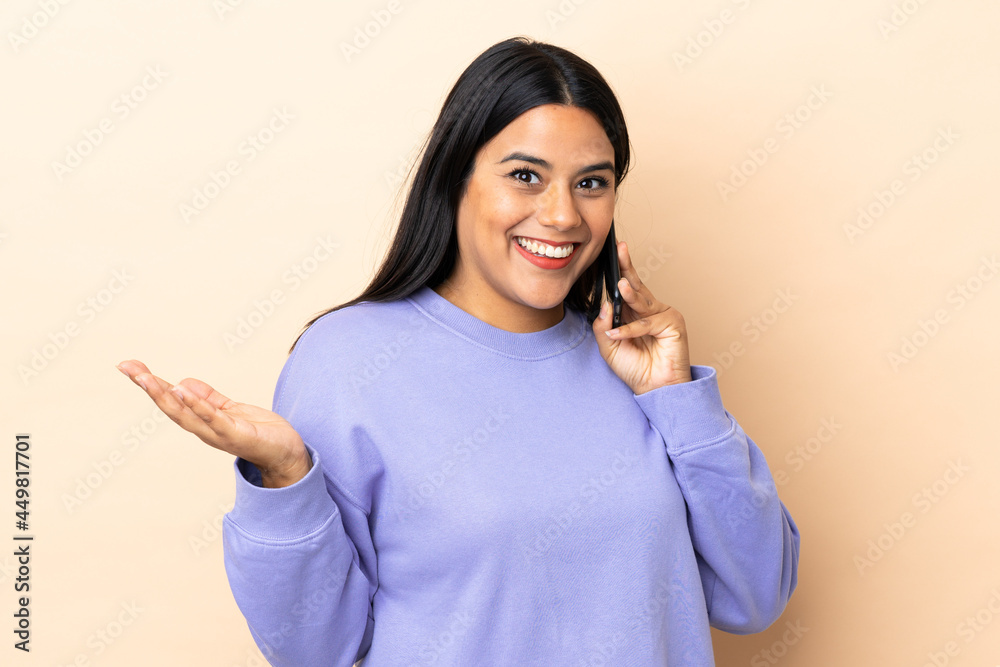 Young latin woman woman over isolated background keeping a conversation with the mobile phone with someone Young latin woman woman over isolated background keeping a conversation with the mobile phone with someone