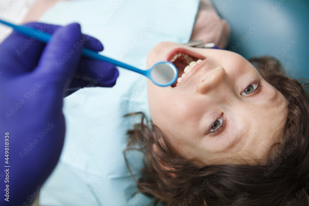 Top view close up of a happy boy getting his teeth examined by dentist Top view close up of a happy boy getting his teeth examined by dentist