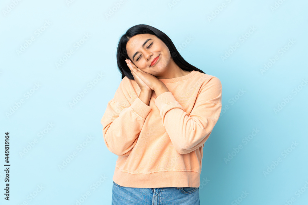 Young latin woman woman isolated on blue background making sleep gesture in dorable expression Young latin woman woman isolated on blue background making sleep gesture in dorable expression