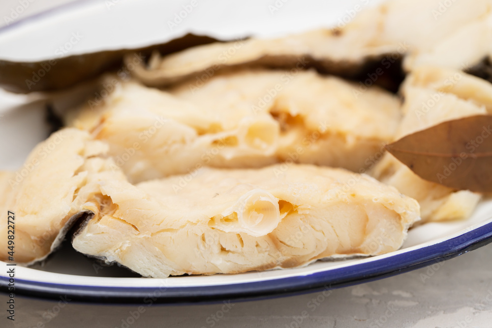 boiled cod fish with bay leaf on white dish boiled cod fish with bay leaf on white dish