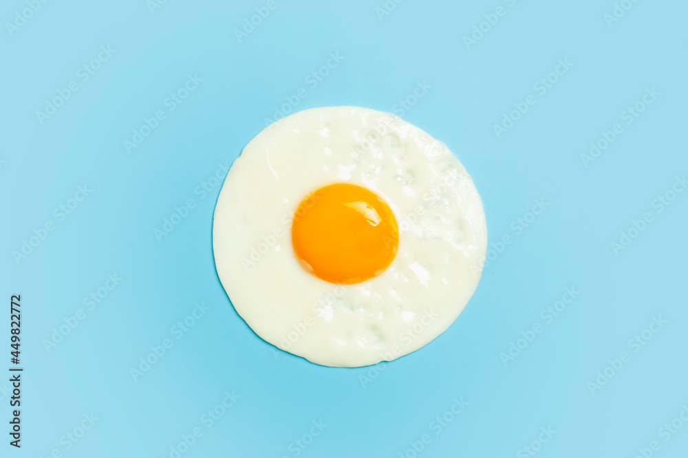 Fried egg is minimal. Fried egg isolate on a blank color light blue background. Creative breakfast and food idea. Fried egg is minimal. Fried egg isolate on a blank color light blue background. Creative breakfast and food idea.
