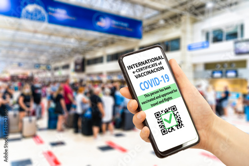 Coronavirus vaccination certificate or vaccine passport for travellers concept. COVID-19 immunity e-passport in the smartphone mobile app for international travelling. Hand with a phone on the